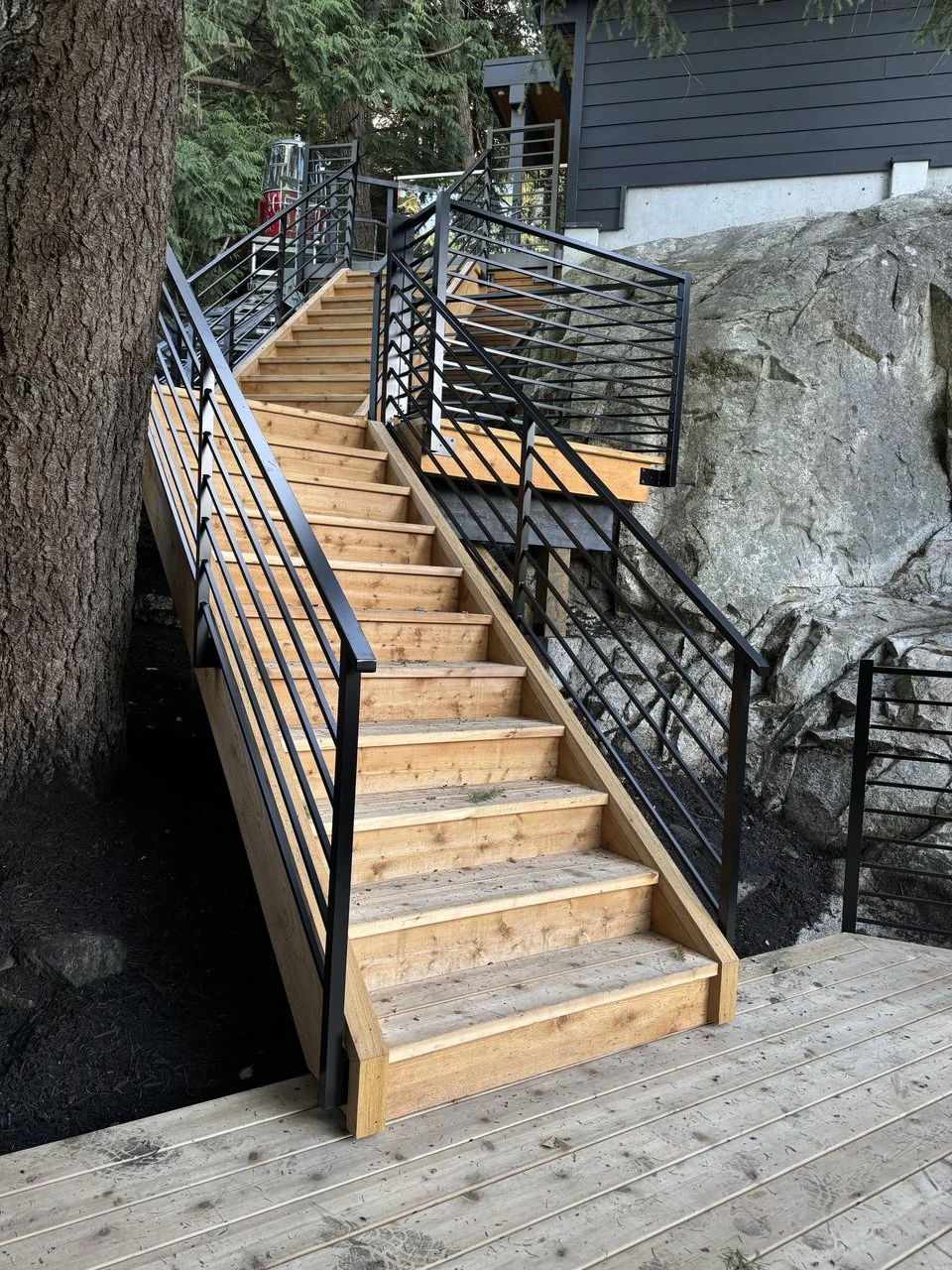 Custom deck stairs and steel railing on a sloped North Vancouver property